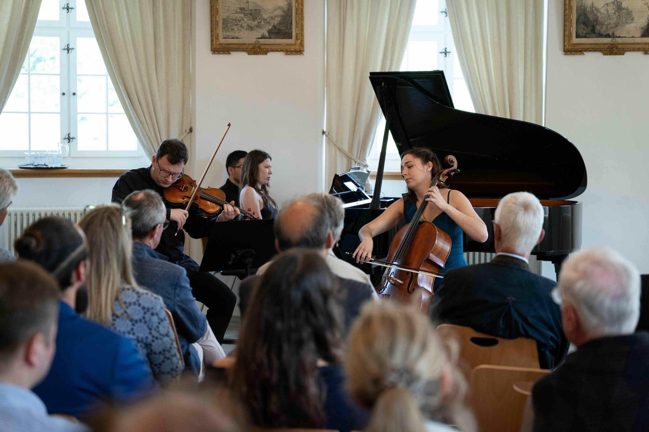 Klaviertrio im Konzertsaal, Publikum im Vordergrund